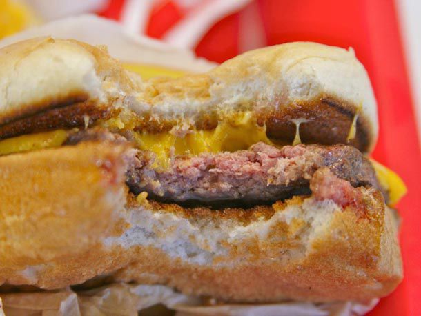 A medium-rare In-N-Out cheeseburger with an extra toasted bun with a bite taken out 