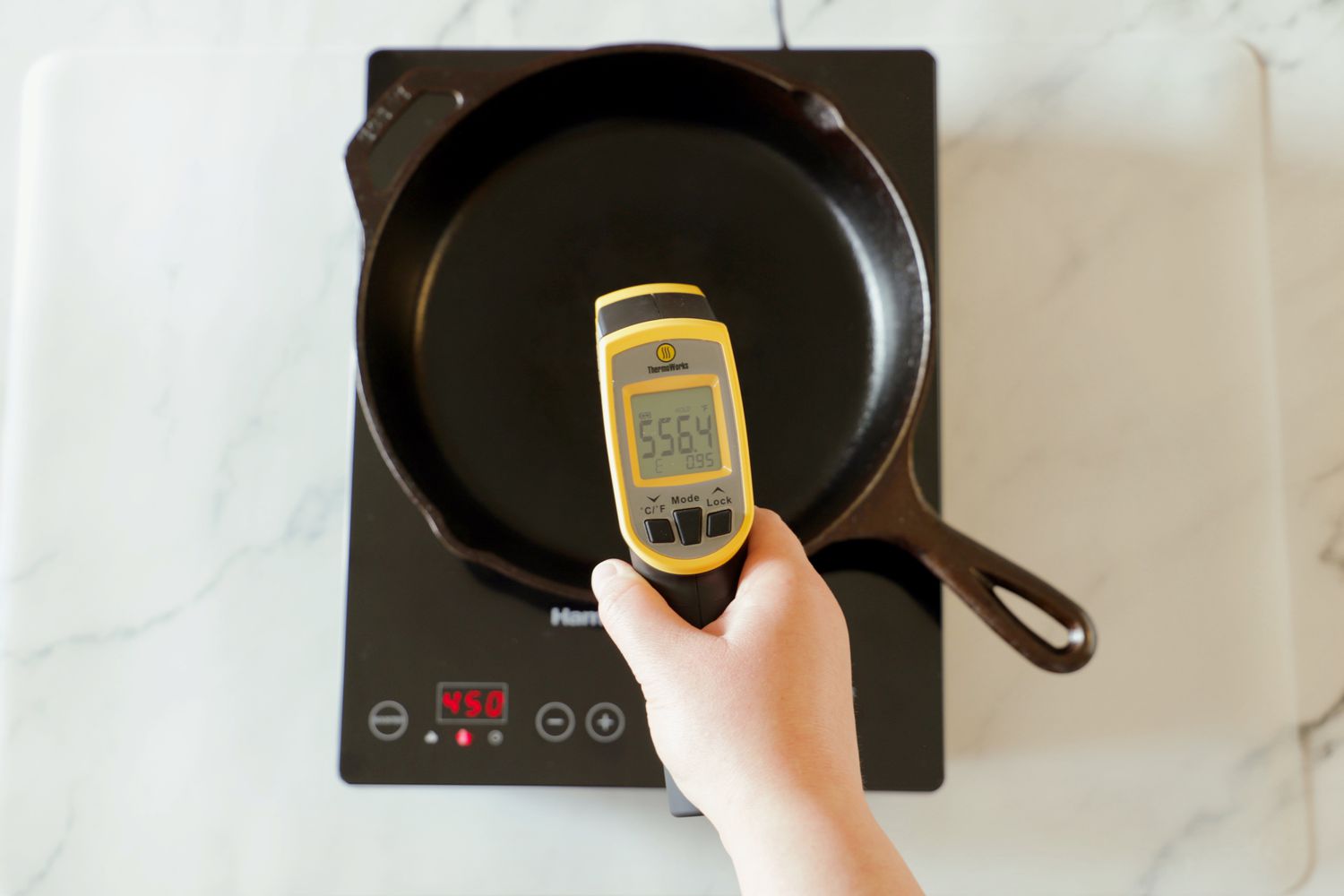 The temperature of a skillet being taken as it heats on an induction cooktop.