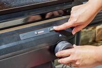 A person presses a button on the Traeger Flatrock Flat Top Grill