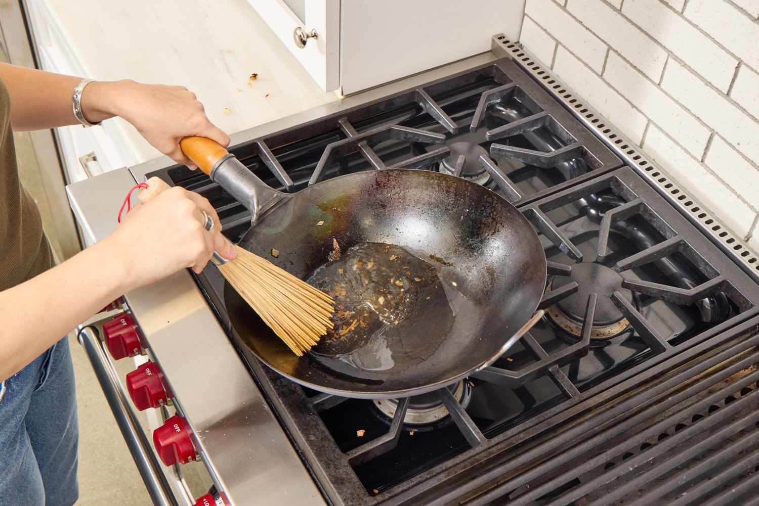 A person oils the bottom of the Yosukata Carbon Steel Wok Pan