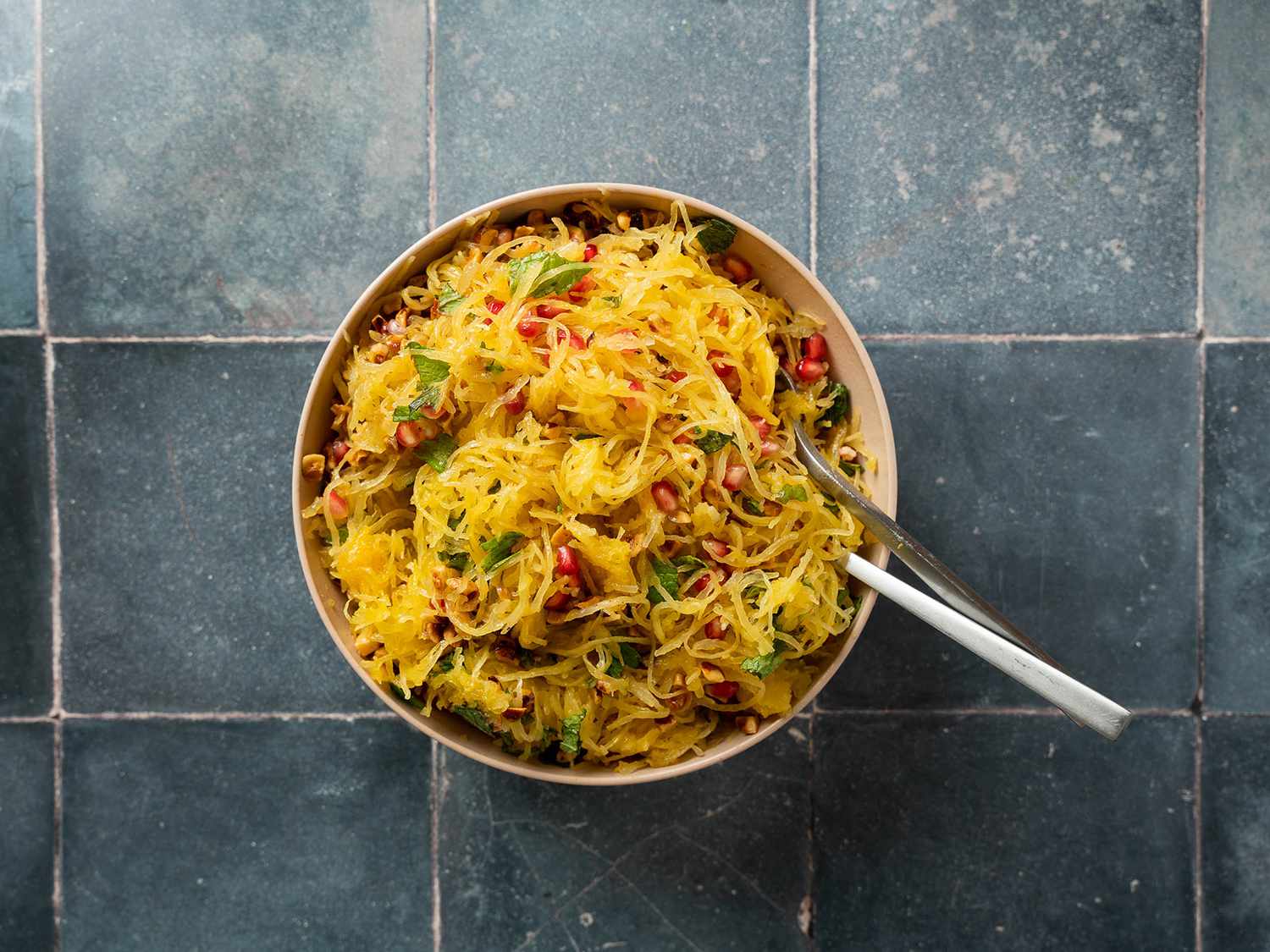 Bowl of spaghetti squash strands with hazelnuts, pomegranate, and mint mixed in