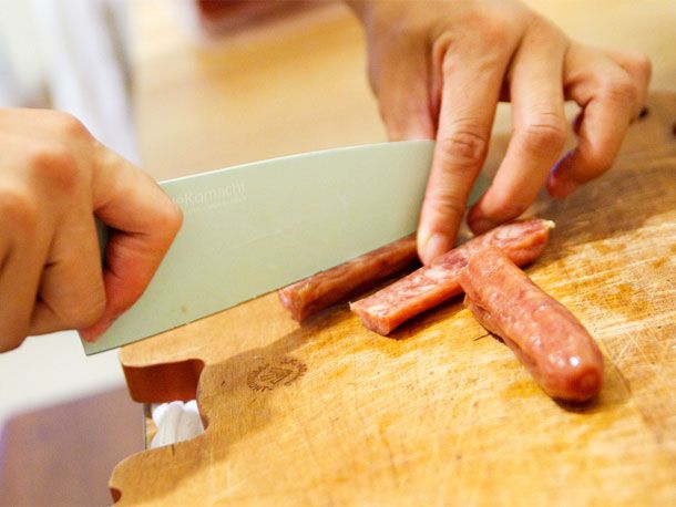 Cutting lap cheong lengthwise.