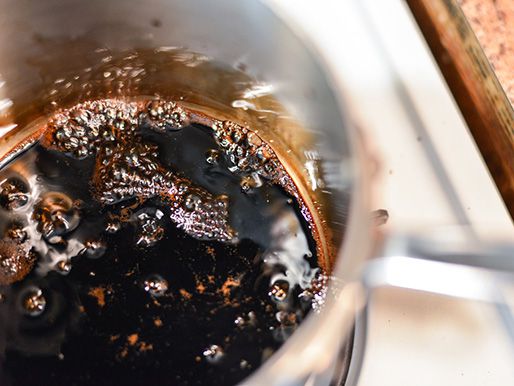 Closeup of balsamic vinegar reducing in a saucepan.