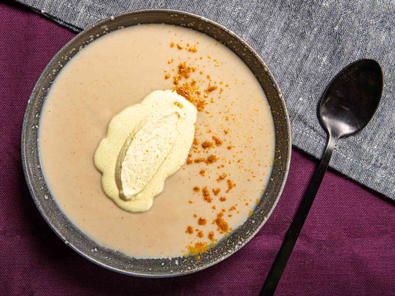 Overhead view of roasted cauliflower soup topped with curry cream