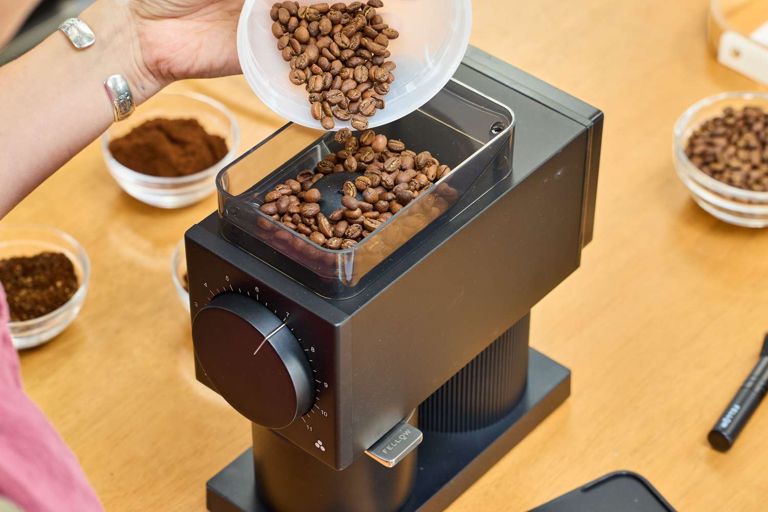 A person pours coffee beans into the Fellow Ode Gen 2 Coffee Grinder