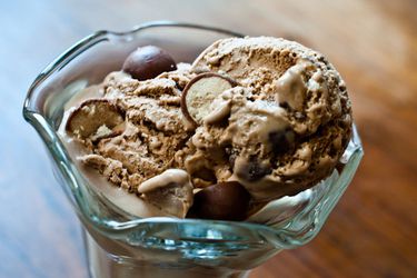 Closeup of two scoops of malted milk chocolate ice cream, served in a parfait glass.