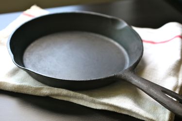 A cast iron skillet resting on a cloth on a table