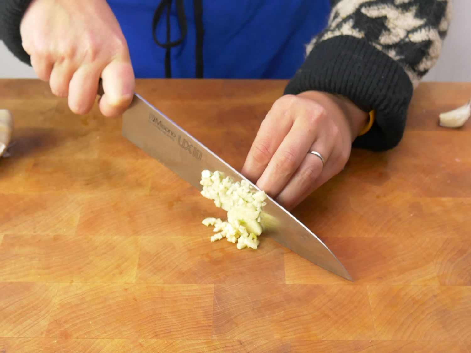 a person using the misono ux10 to minc garlic