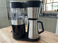 The OXO Brew 9-Cup Coffee Maker on a wooden surface in a kitchen.