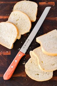 Tojiro F-737 Bread Slicer next to sliced bread