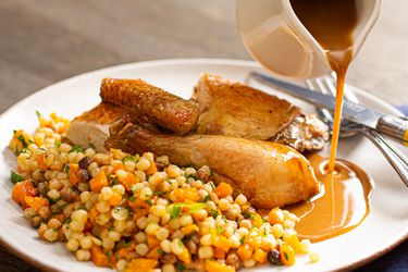 Roast chicken with grains on a plate.