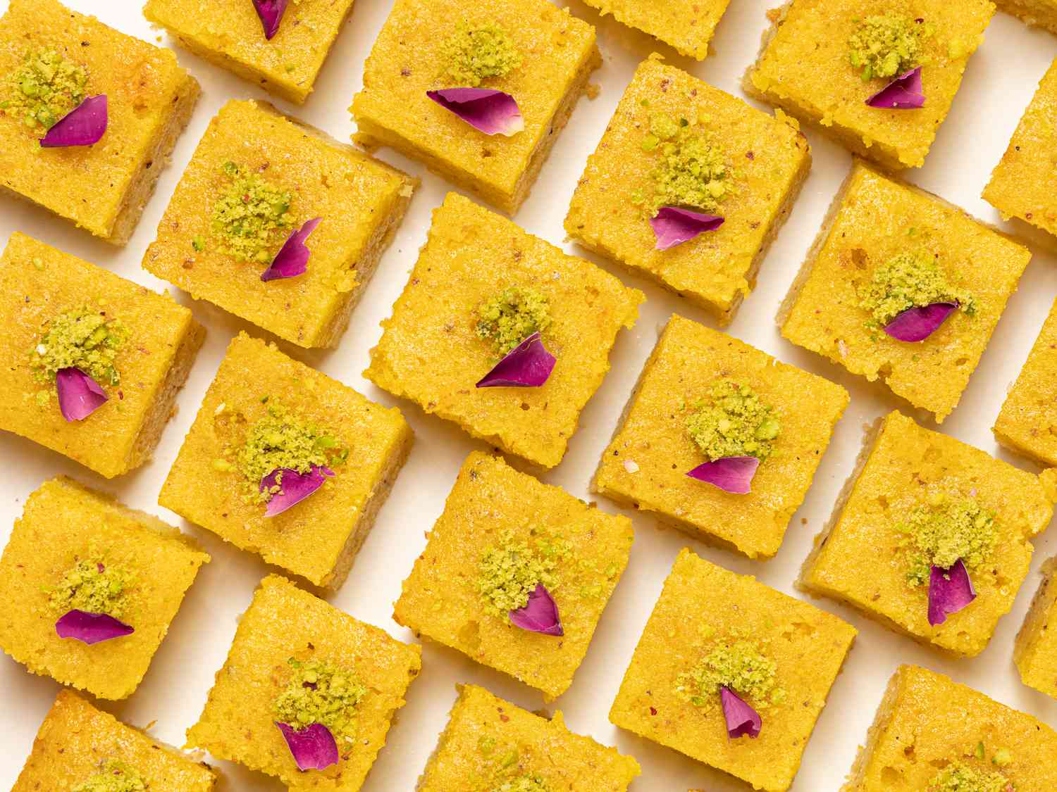 Baklava cake squares lined up on a white surface 