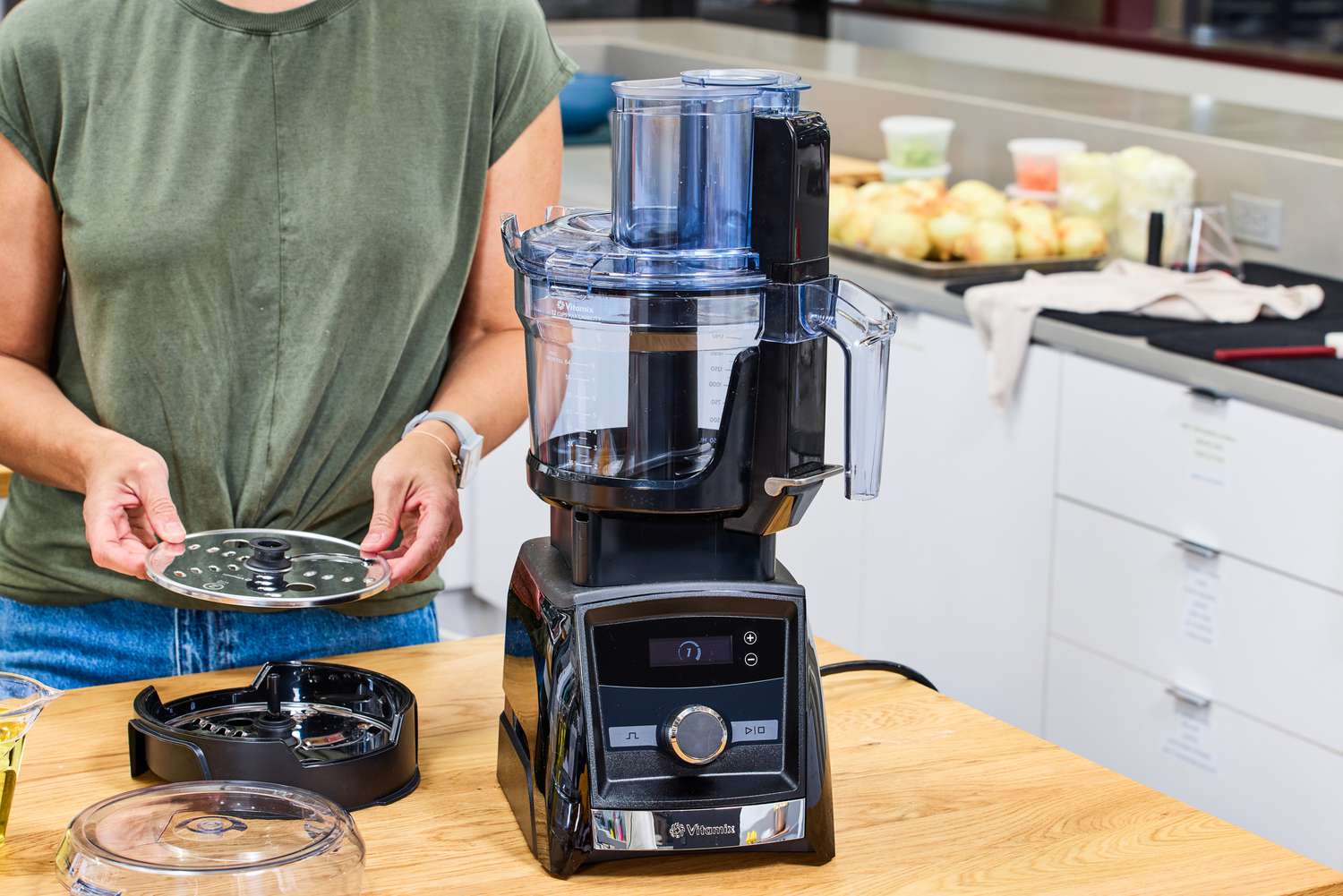 A person assembles the Vitamix 12-Cup Food Processor Attachment
