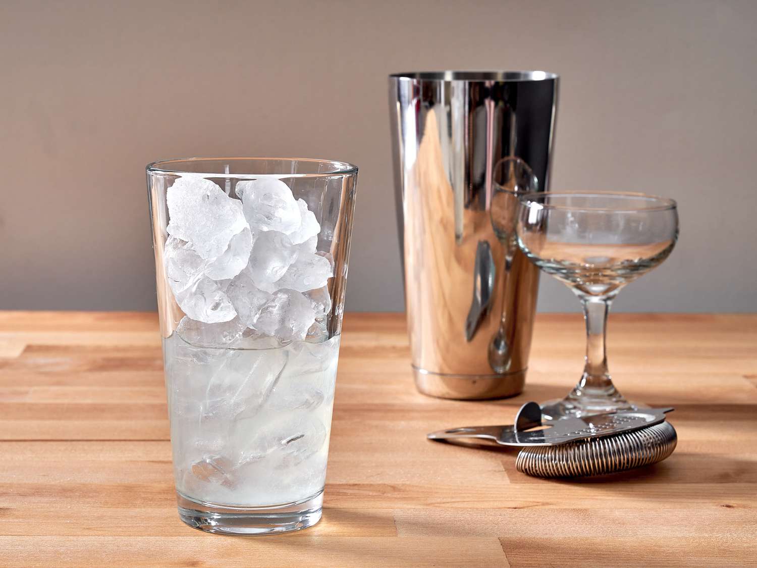 a cocktail shaker with ice and gin, lemon juice and Cointreau