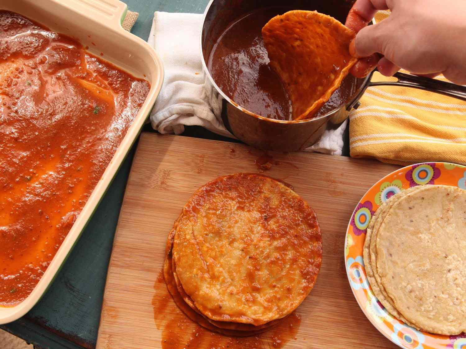The fried corn tortillas are dipped in the puréed sauce and stacked for final assembly.