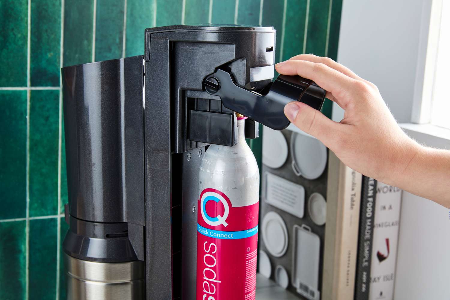 A person loading a CO2 cartridge into a soda maker
