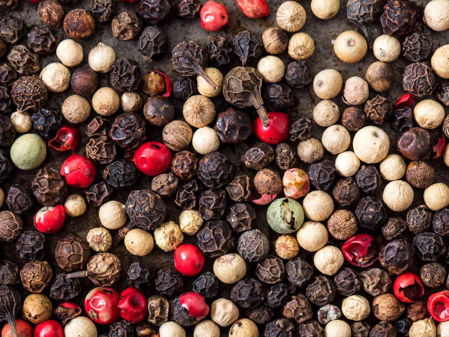 Macro shot of a mix of different kinds of peppercorns.