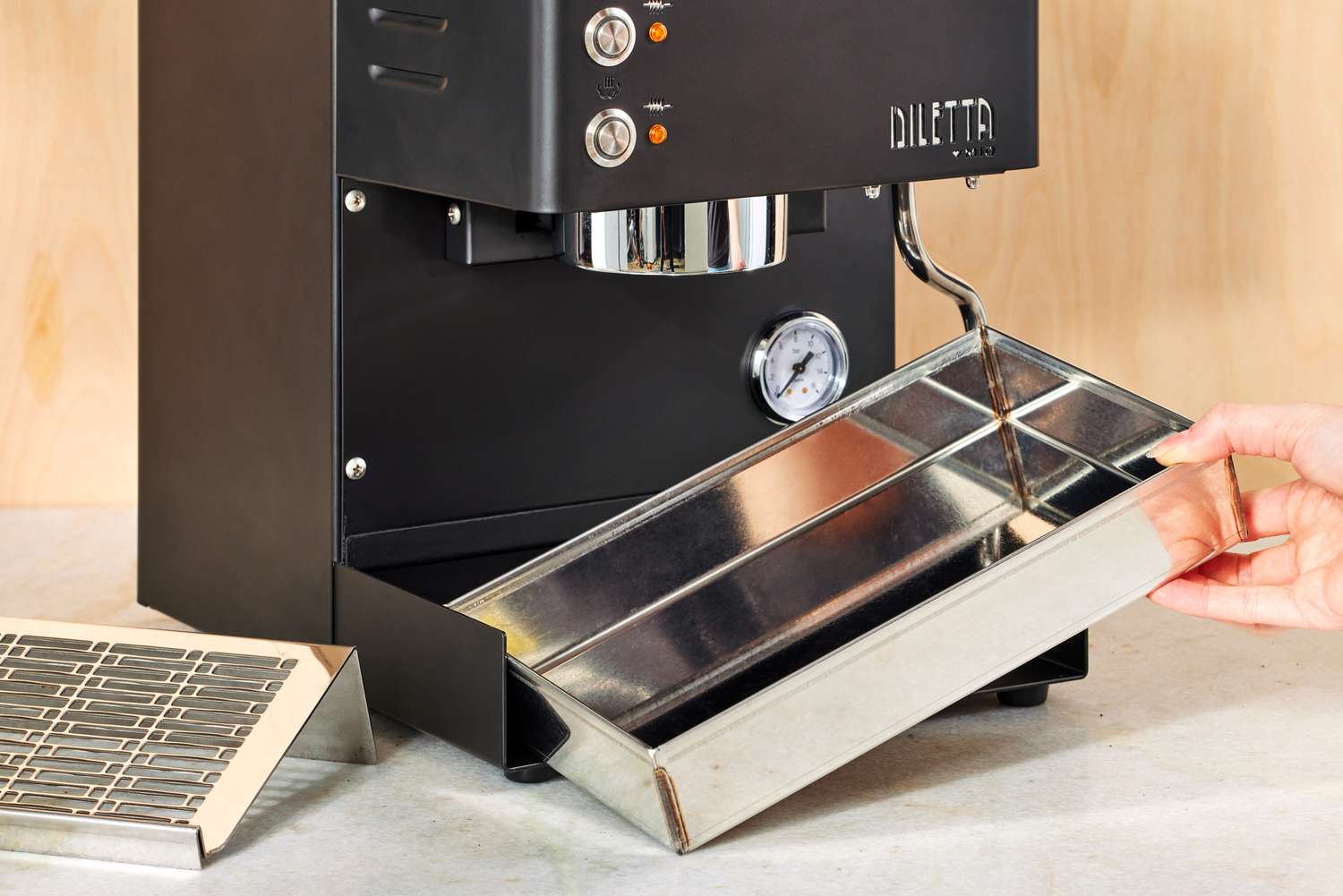 A person adjusting the tray under the Diletta Mio Espresso Machine