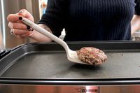 A person using the Material Soft-Edged Turner to flip food