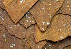 Shingled pieces of sourdough rye crackers sprinkled with flaky salt, coriander, and fennel seeds