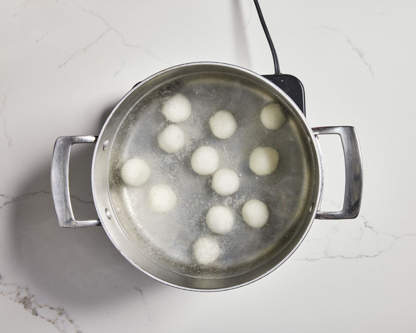 Tang yuan cooking in a pot of water.