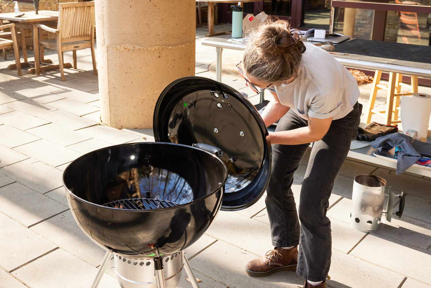 The lid of a charcoal grill is inspected