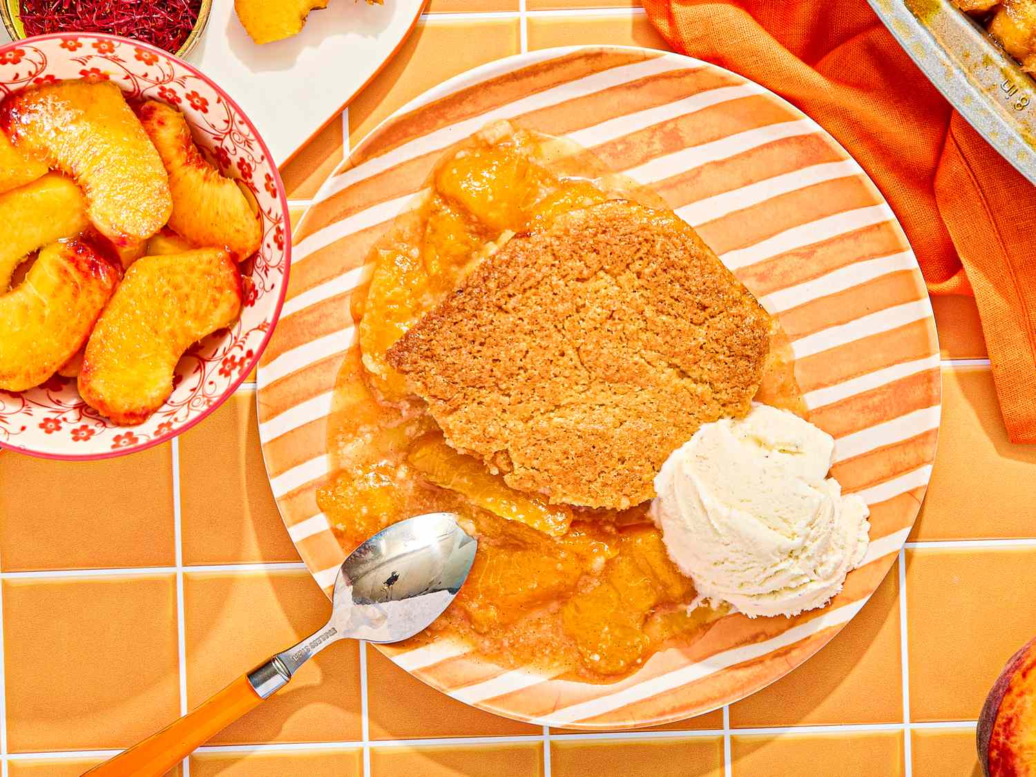 Peach cobbler with ice cream on a striped plate