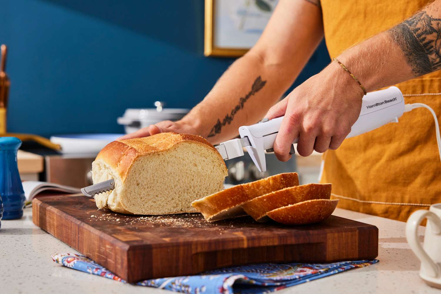 using an electric knife to slice a piece of bread from a loaf