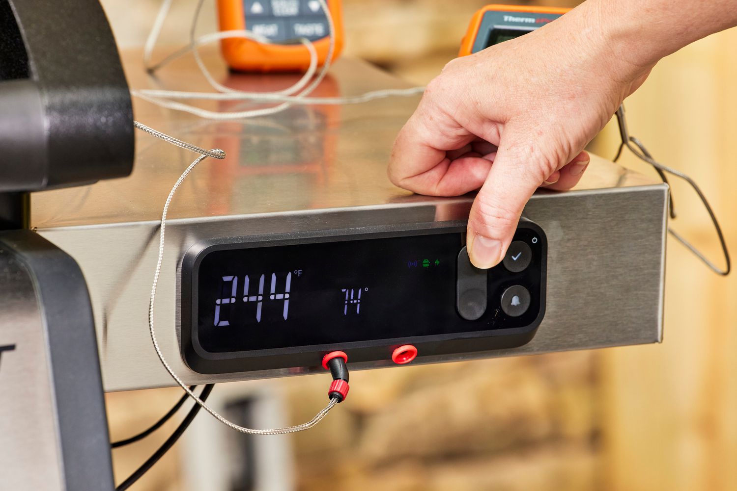 A person presses a button on the Weber Spirit EX-325s Smart Grill