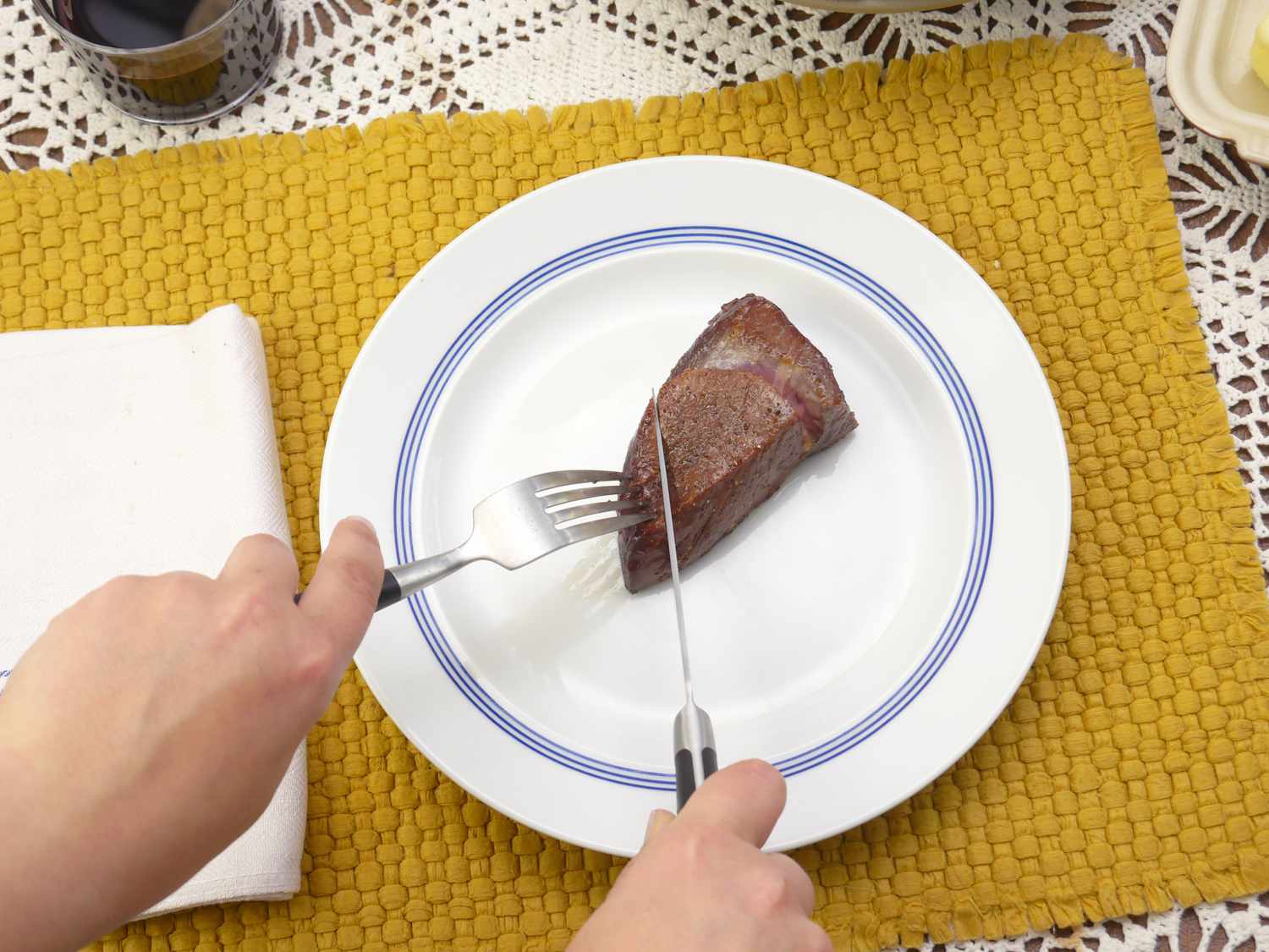 a person using the quince steak knife to slice a piece of steak