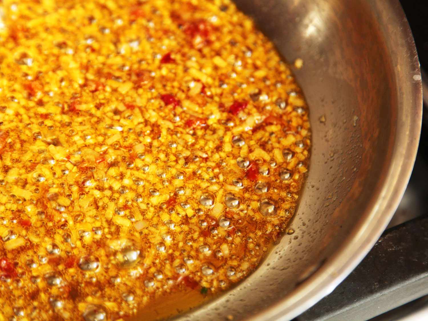 Minced garlic and shallot and Calabrian chili sauce sautéing in olive oil.