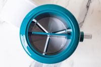 Closeup of MANBA Ice Shaver and Snow Cone Machine with internal spokes on a white surface