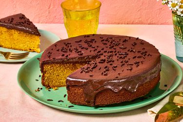 Brazilian carrot cake topped with chocolate glaze, a slice is served nearby