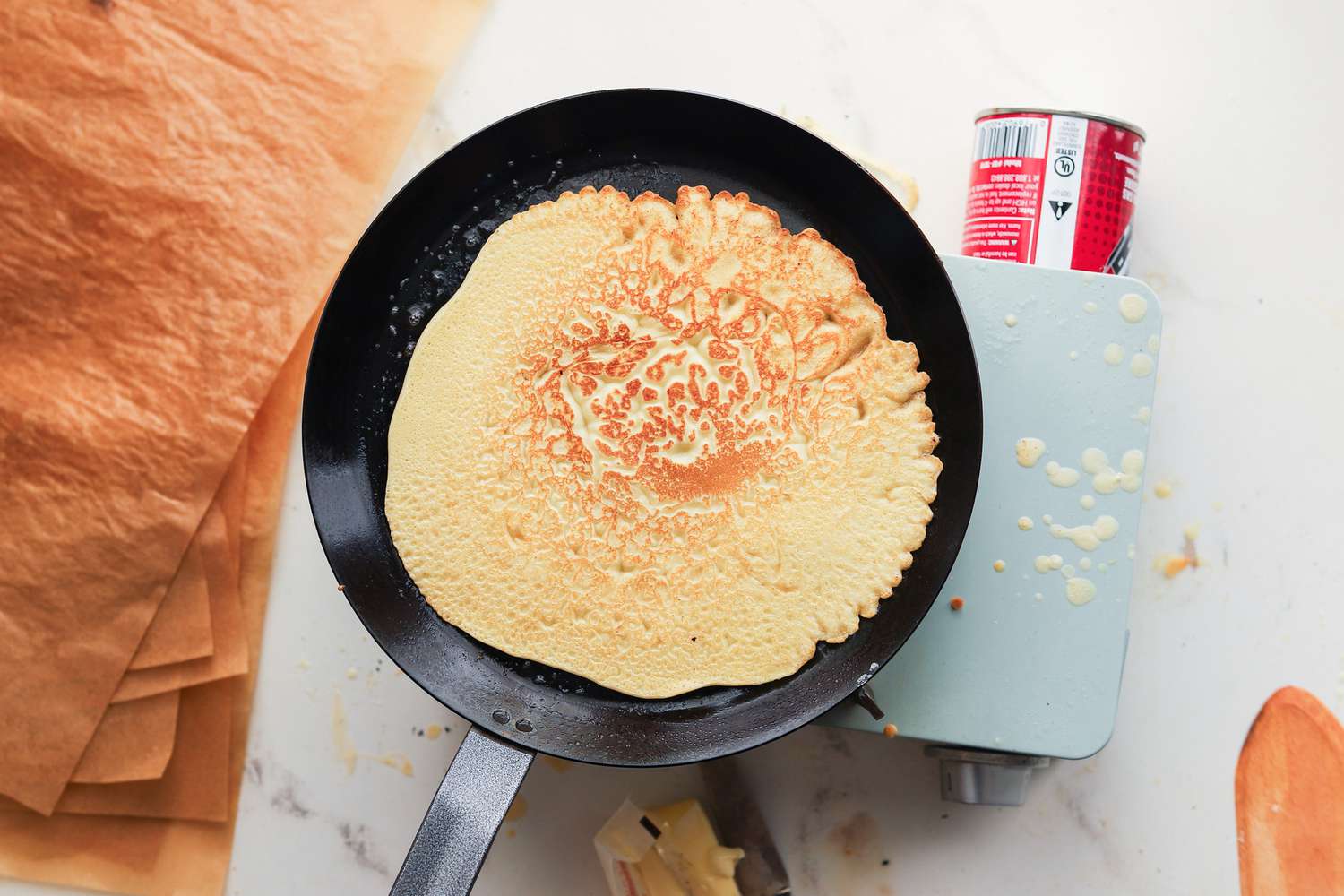 A browned crepe on a carbon steel crepe pan.