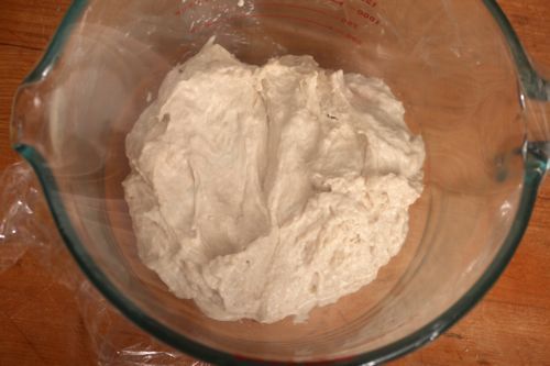 Bread dough in early stage of fermentation in large glass measuring bowl