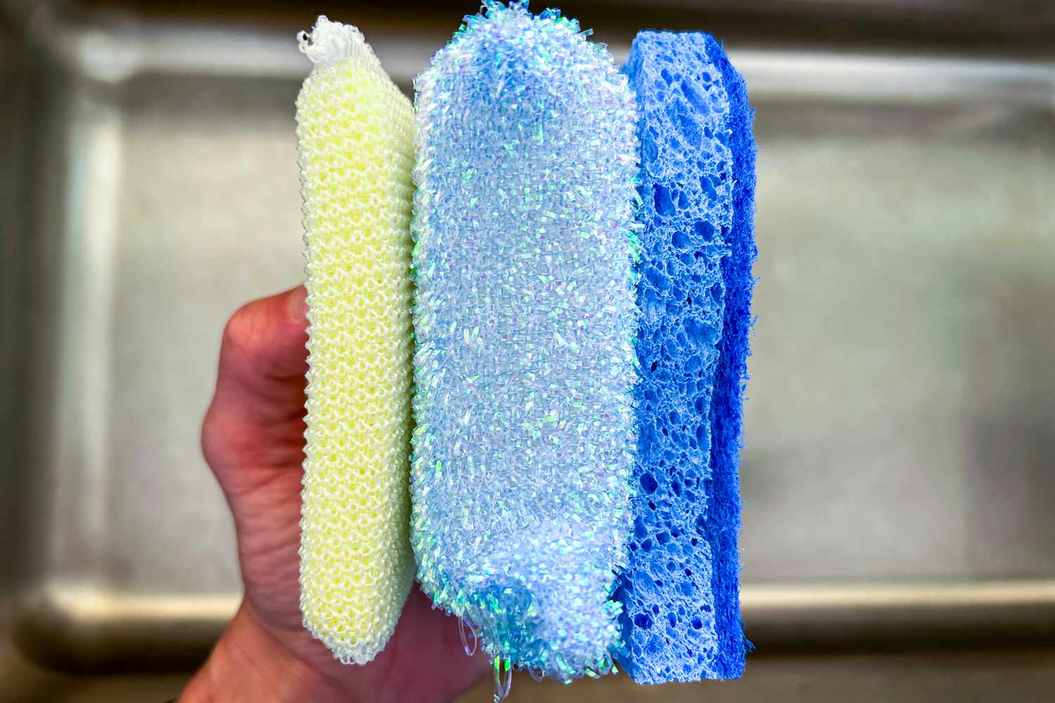 Three dishwashing sponges held side-by-side.