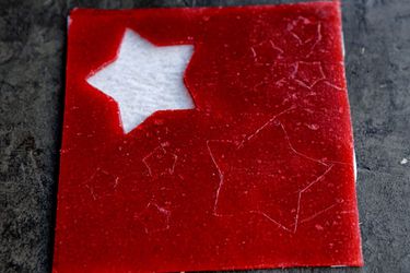 A square of homemade strawberry fruit roll-up with star cut-out.