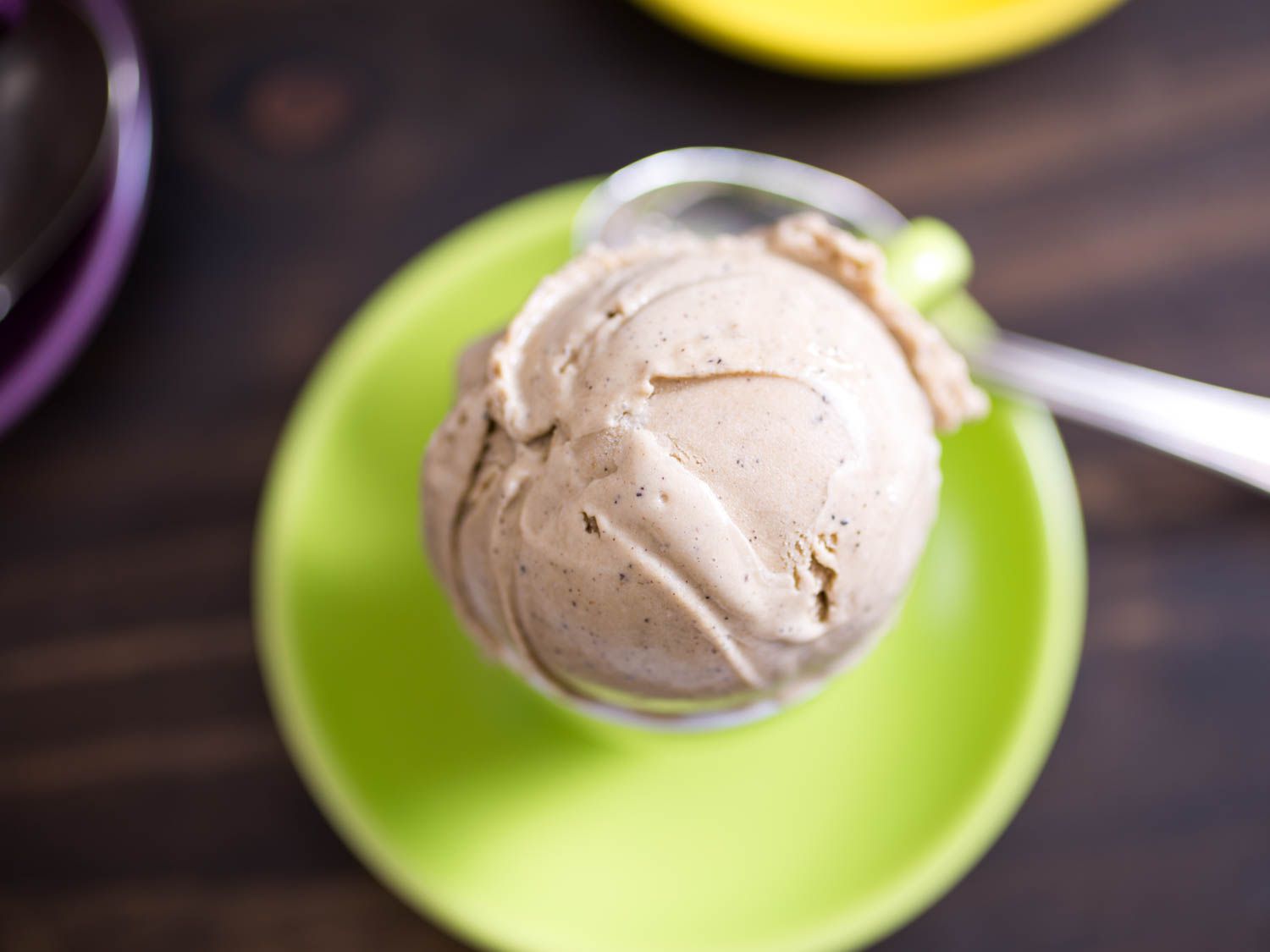 Overhead of a scoop of homemade coffee ice cream with a spoon below.