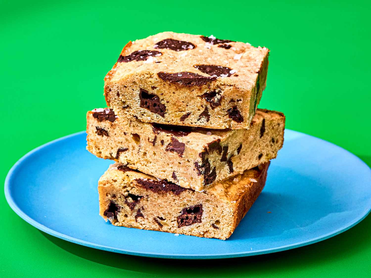 Three banana bread blondies stacked on a blue plate