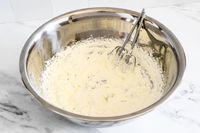 Whipped cream in a large Vollrath mixing bowl with beaters
