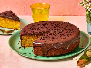Brazilian carrot cake topped with chocolate glaze, a slice is served nearby