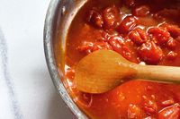 Cooking tomatoes in a pot with a Field Company Cherry Wood Spoon