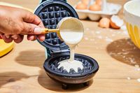 Person pouring batter into Dash Mini Waffle Maker