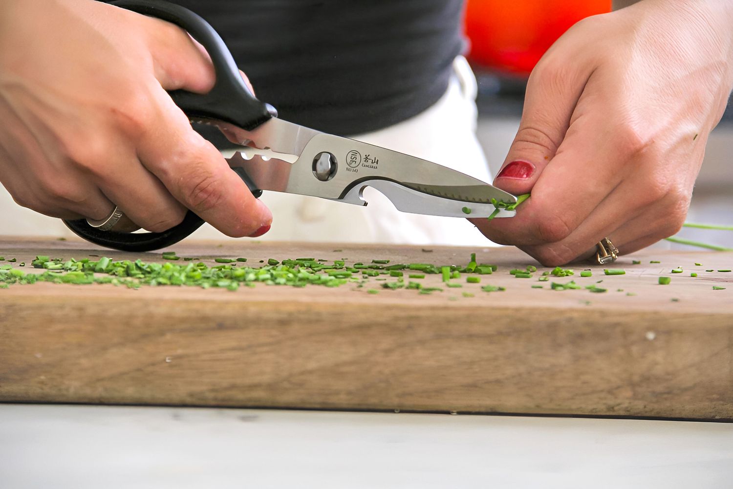 A person cutting chives using the Cangshan 9-inch Heavy-Duty Come-Apart Kitchen Shears