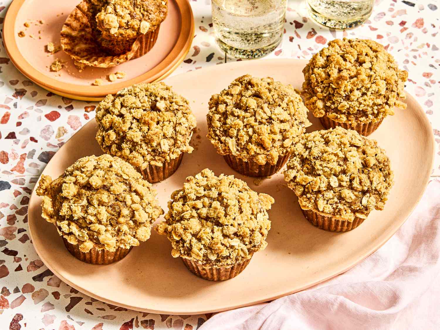 Tray with banana oatmeal muffins next to glasses of sparkling drinks