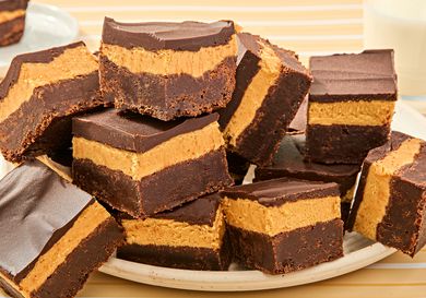 A plate of triplelayer peanut butter brownies with chocolate and peanut butter layers