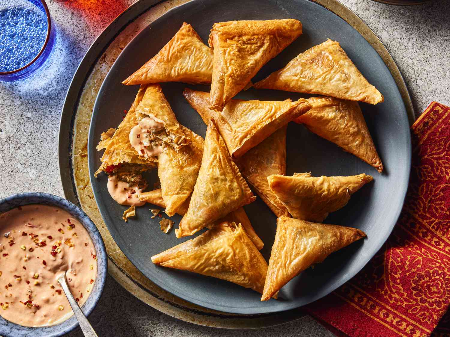Overhead view of Kefta Briouates on a plate with dipping sauce on the side