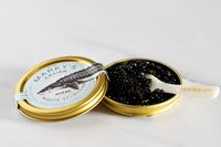 A tin of royal white sturgeon caviar with a mother-of-pearl spoon set inside