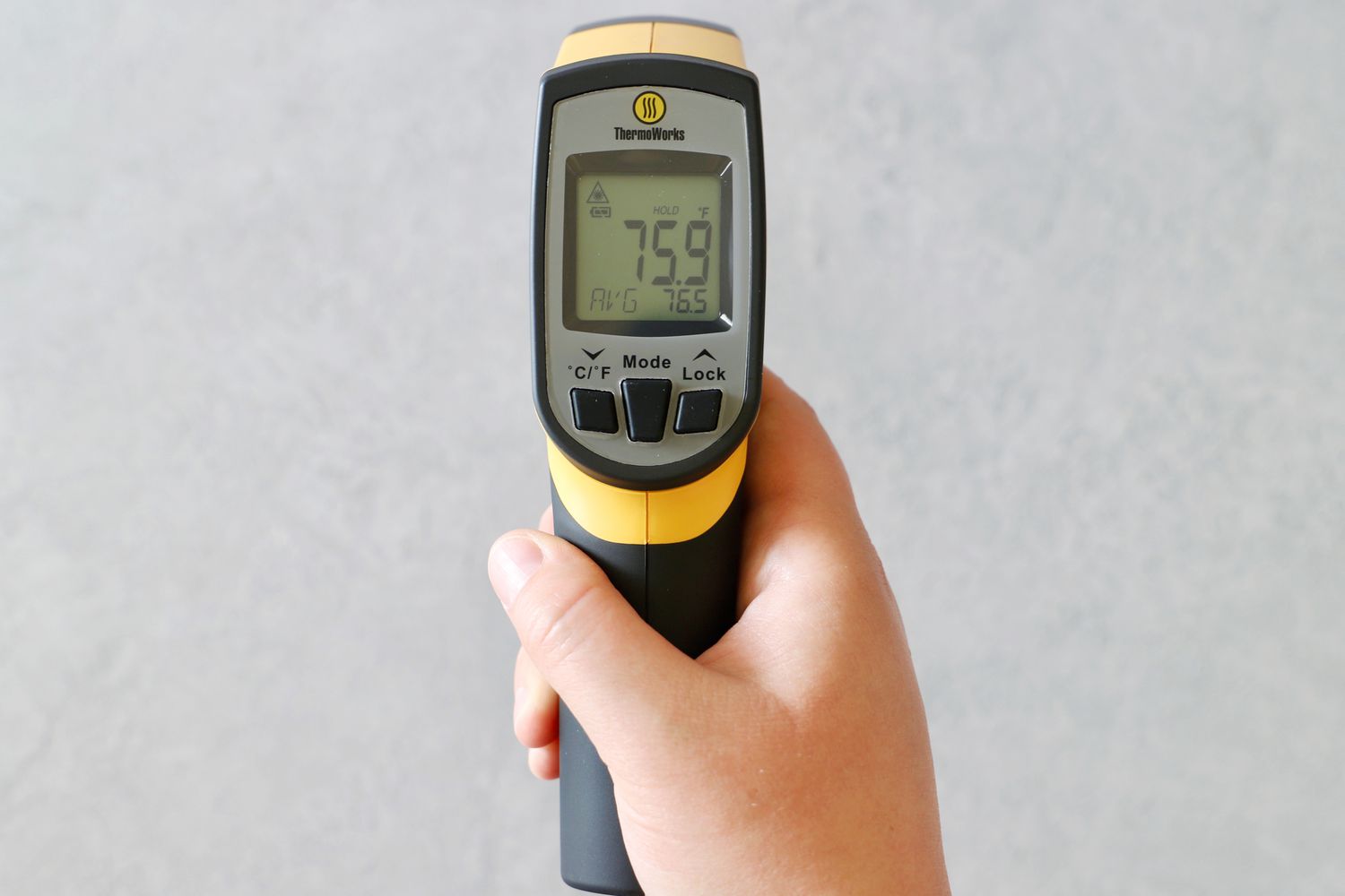 A person holding an infrared thermometer.
