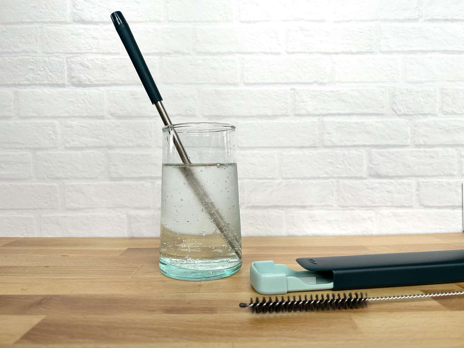 A metal and silicone straw in a glass of sparkling water